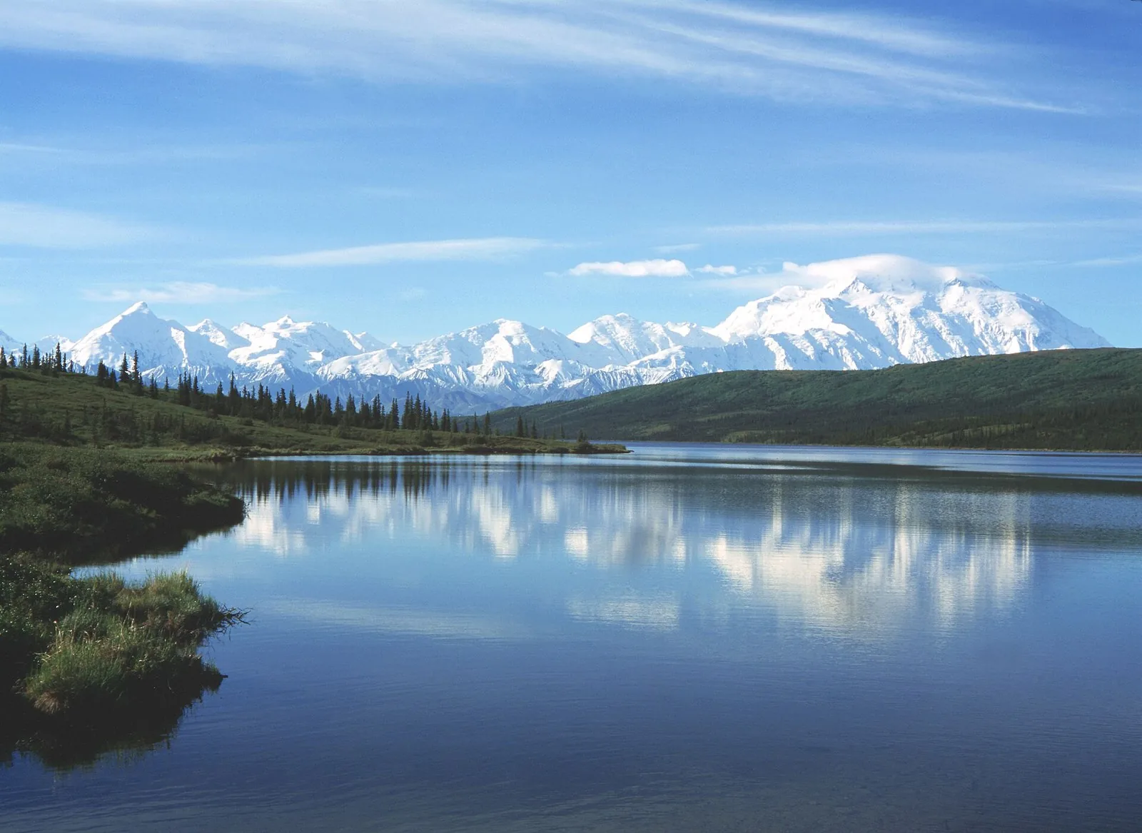 Snow-covered Denali and the Alaska Range reflected in the still water of Wonder Lake, the view that draws many travelers to an Alaska cruise and land tour
