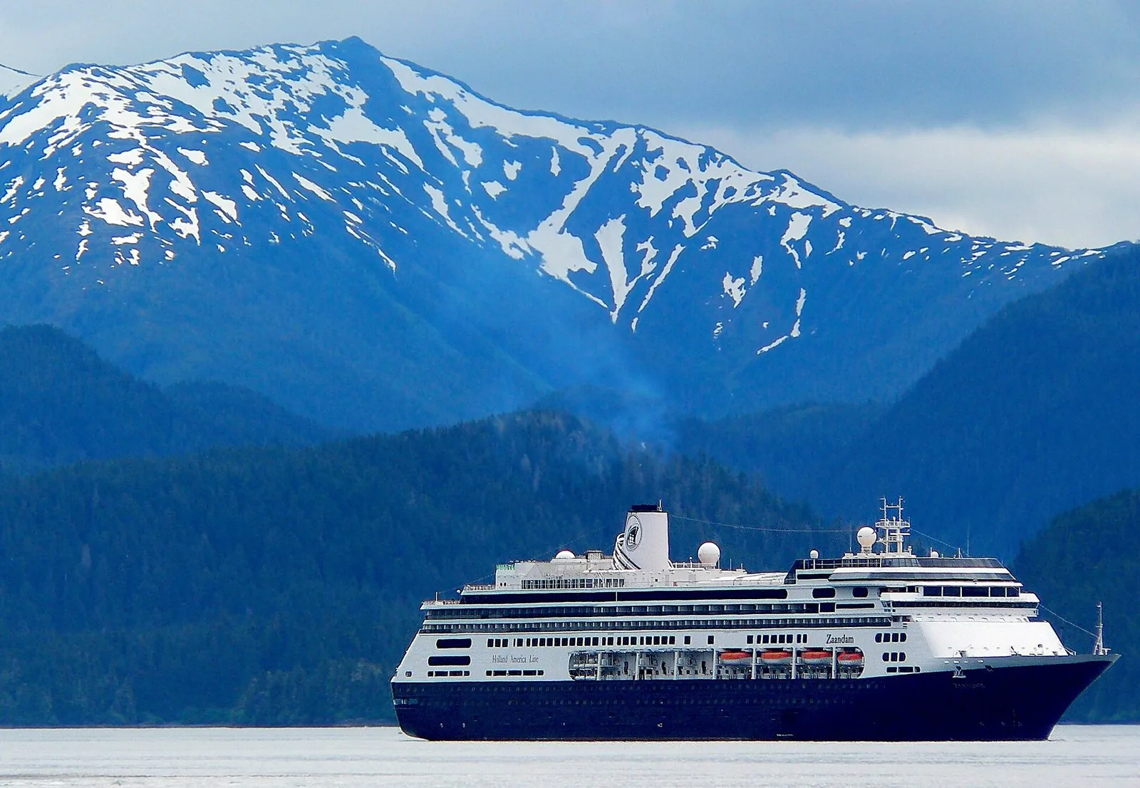 Holland America's Zaandam anchored off Sitka below a snow-streaked mountain; Sitka is a prized fourth port on an Alaska cruise itinerary