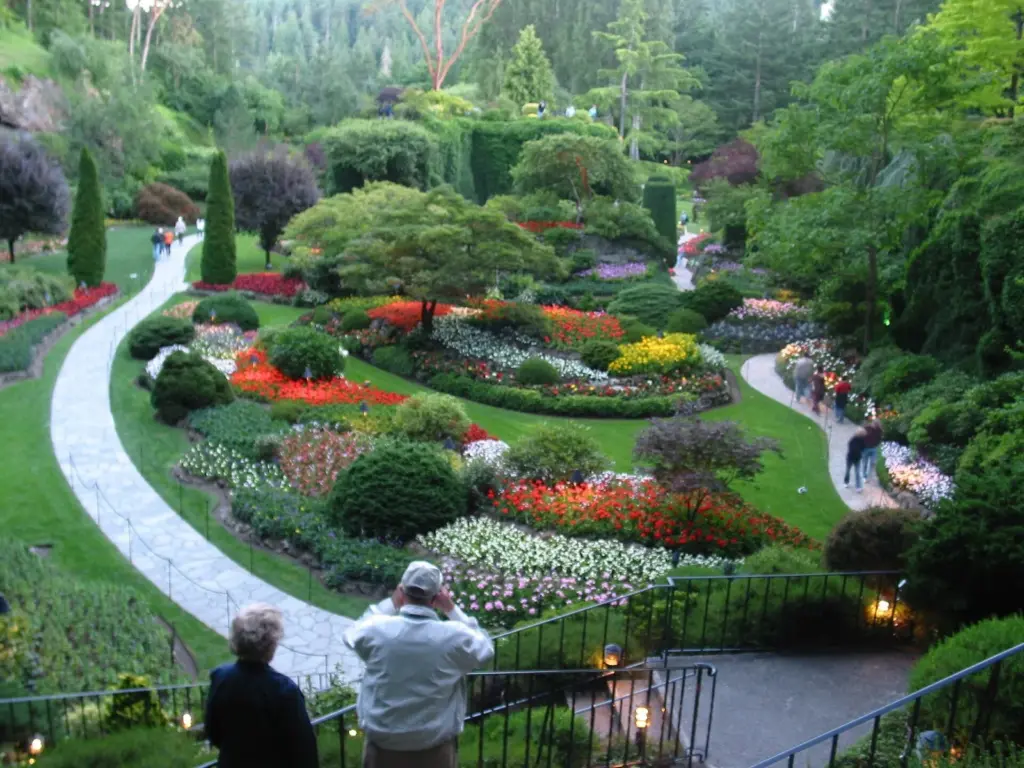 Visitors looking down over the flower beds and winding paths of the Sunken Garden at Butchart Gardens
