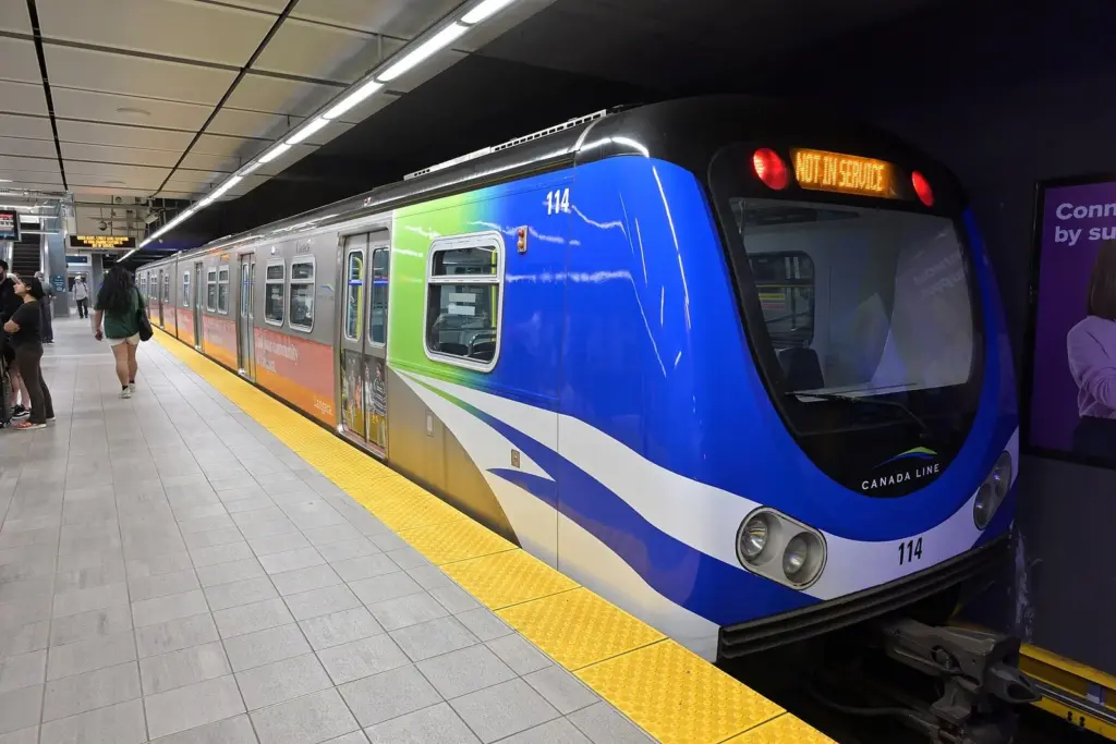 Blue and white Canada Line SkyTrain car at an underground platform at Waterfront Station