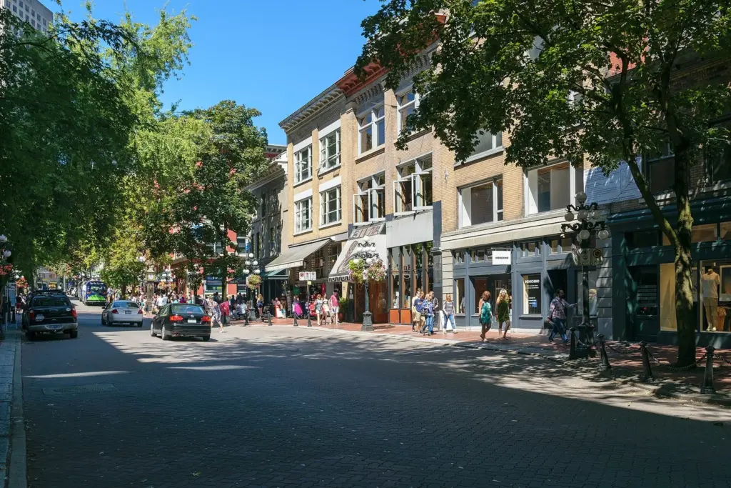 Brick buildings, shops and pedestrians on a cobbled street in Gastown, Vancouver