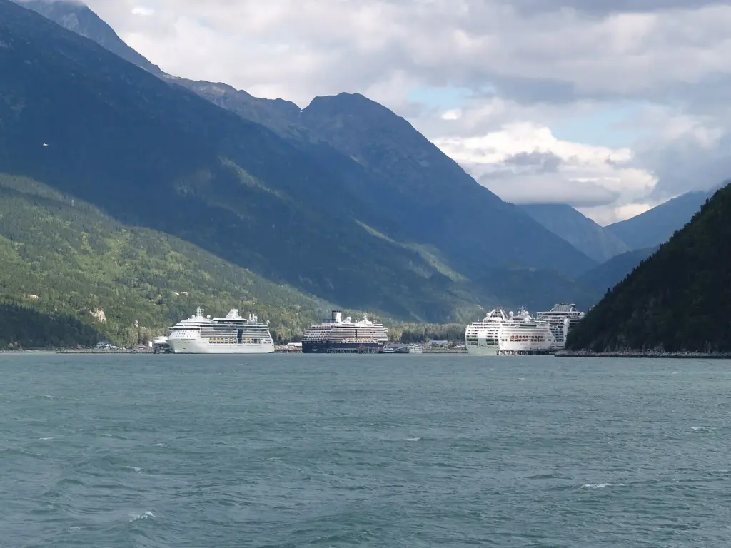 Cruise ships docked at Skagway at the head of Lynn Canal, seen from the water with steep green mountains on both sides
