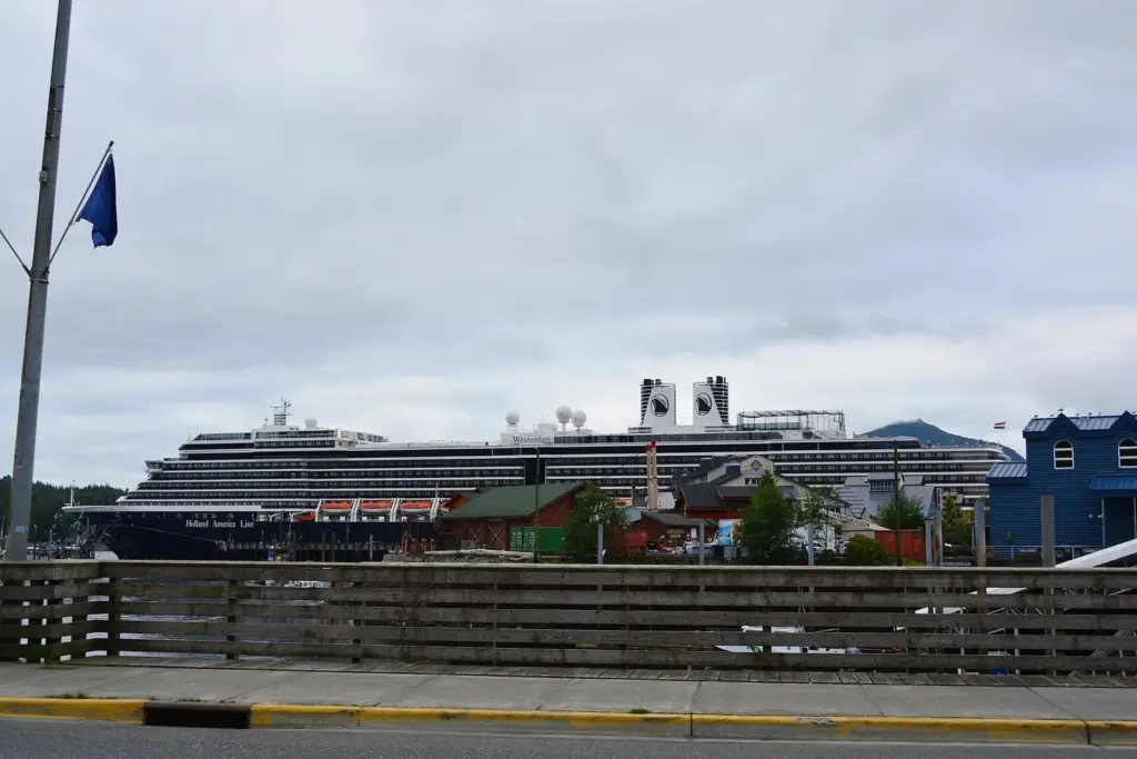 Holland America's Westerdam docked in Ketchikan beyond waterfront buildings under a cloudy sky