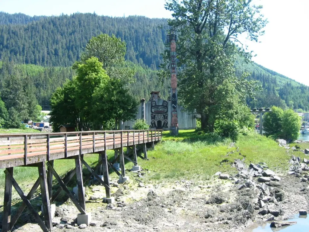 Boardwalk leading across the tide flats to Shakes Island and its tribal house and totem poles in Wrangell